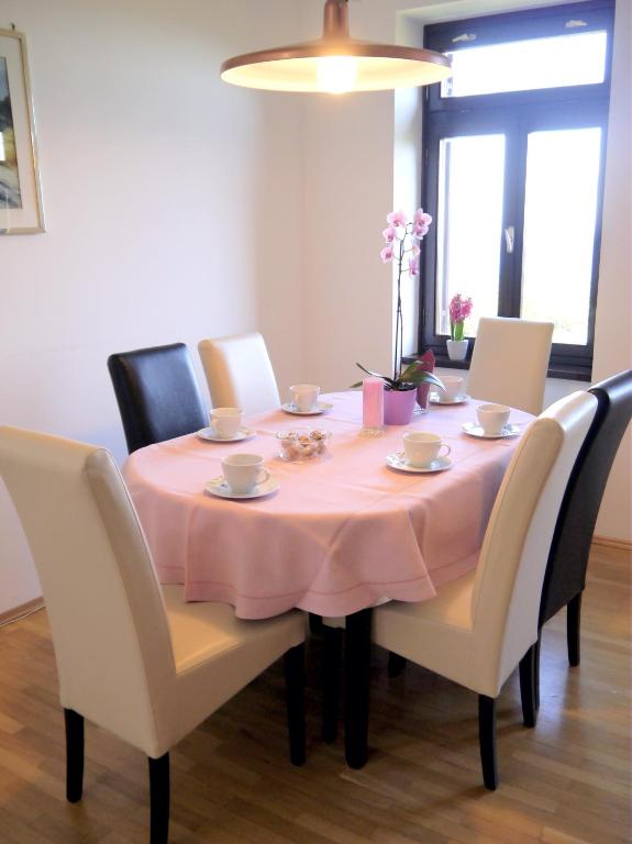 a dining room table with a pink table cloth on it at Apartments Vrutki in Opatija