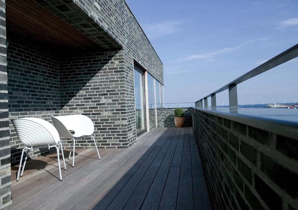 a balcony with two chairs and a view of the water at Charlottehaven in Copenhagen