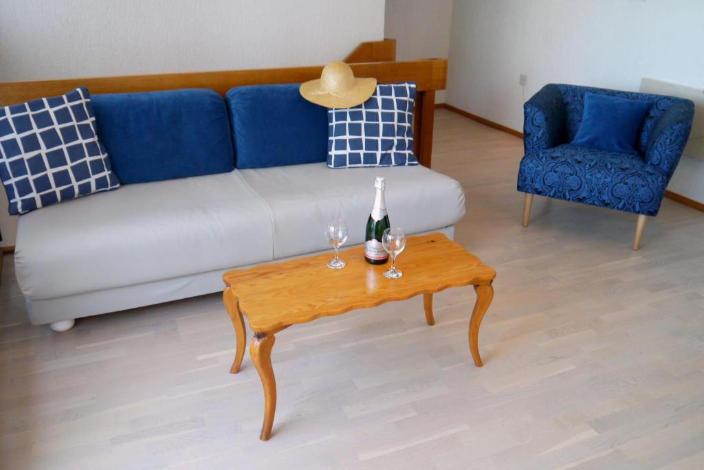 a living room with a couch and a table with wine glasses at Apartments Vrutki in Opatija