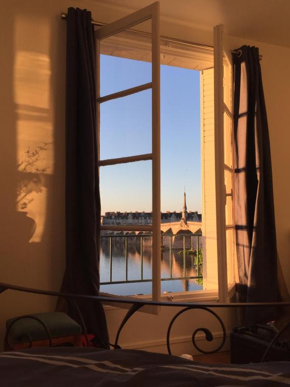 a bedroom window with a view of a bridge at Les lumières de la Loire in Blois