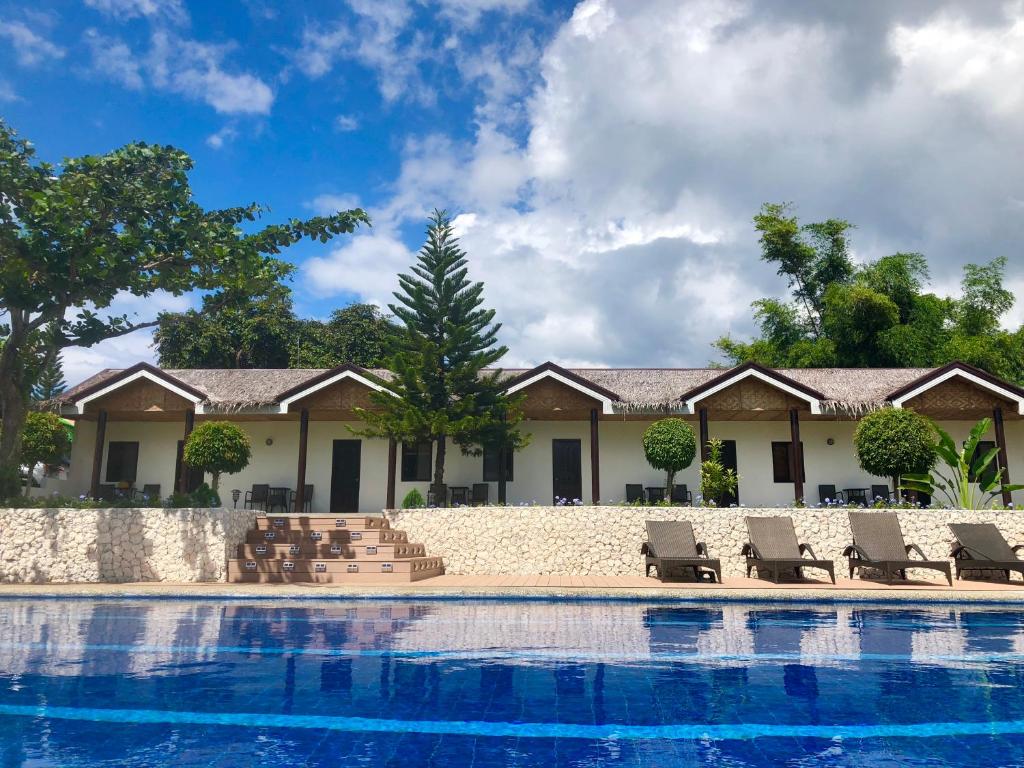 um resort com piscina e espreguiçadeiras em Casa de Moalboal em Moalboal