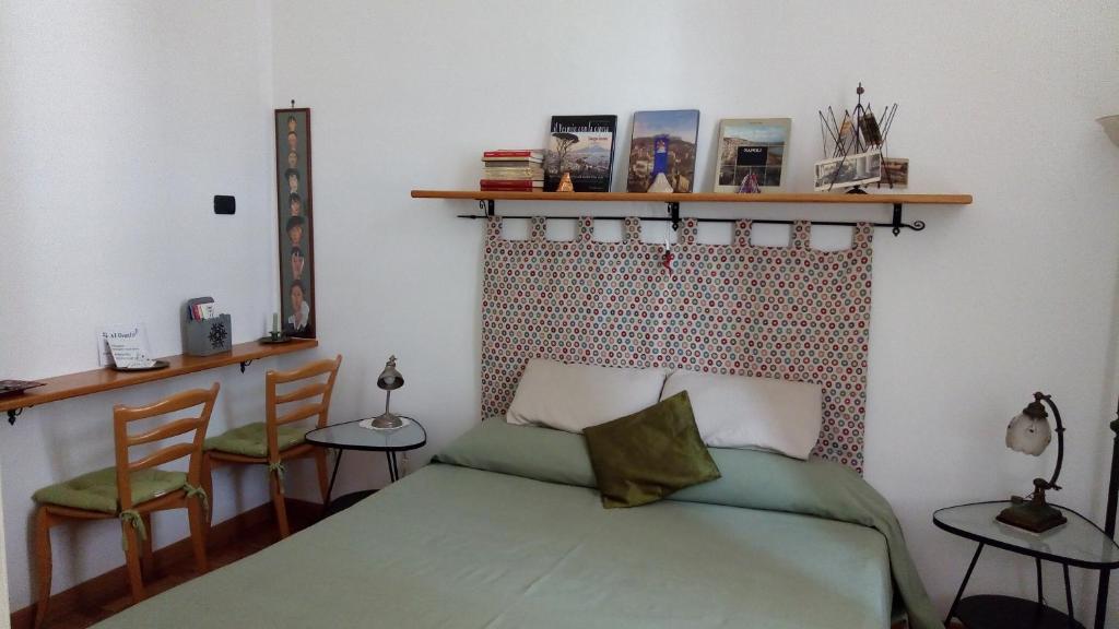 ナポリにあるB&B Al Ponteのベッドルーム1室(緑のベッド1台、椅子2脚付)