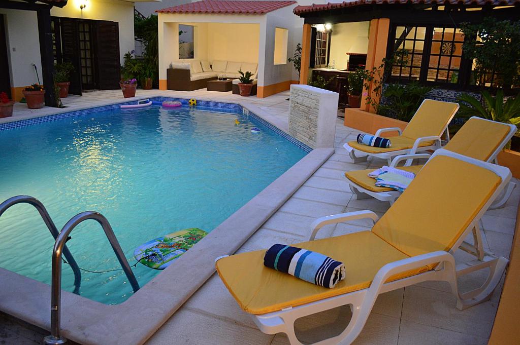 a swimming pool with lounge chairs and a swimming pool at Casa Grande Holidays in São Martinho do Porto