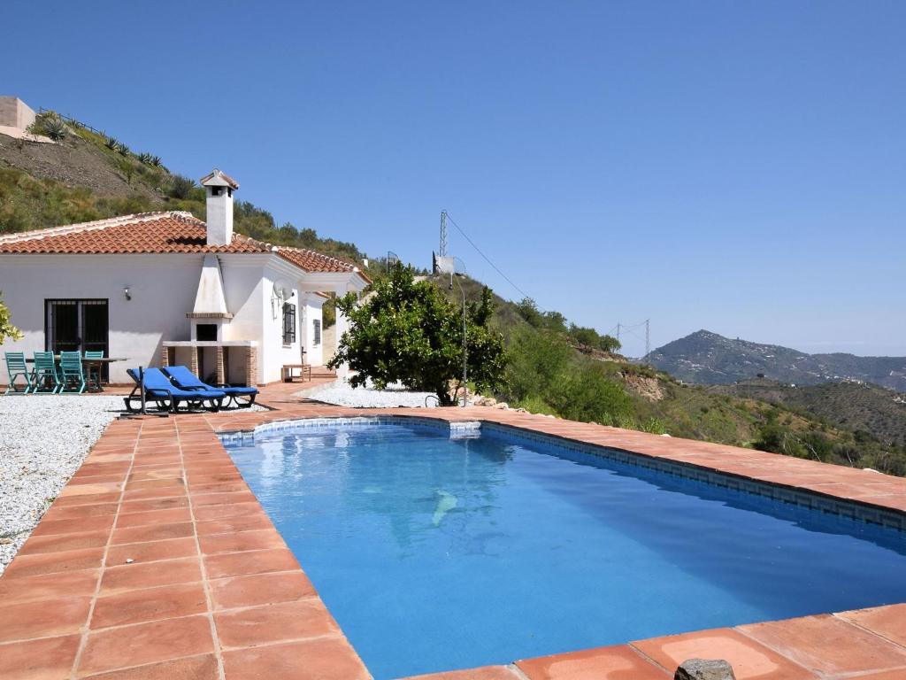 a swimming pool in front of a house at Belvilla by OYO Villa Las Reinas in Arenas