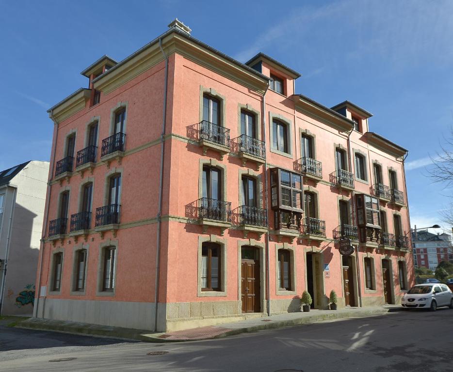 a large brick building on the side of a street at La Casona de Lazúrtegui in Ribadeo