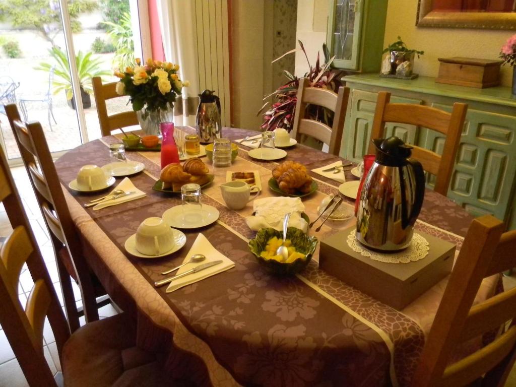 a dining room table with a table set with food at Le Logis d&#39;ANTIGNY in Val-du-Mignon