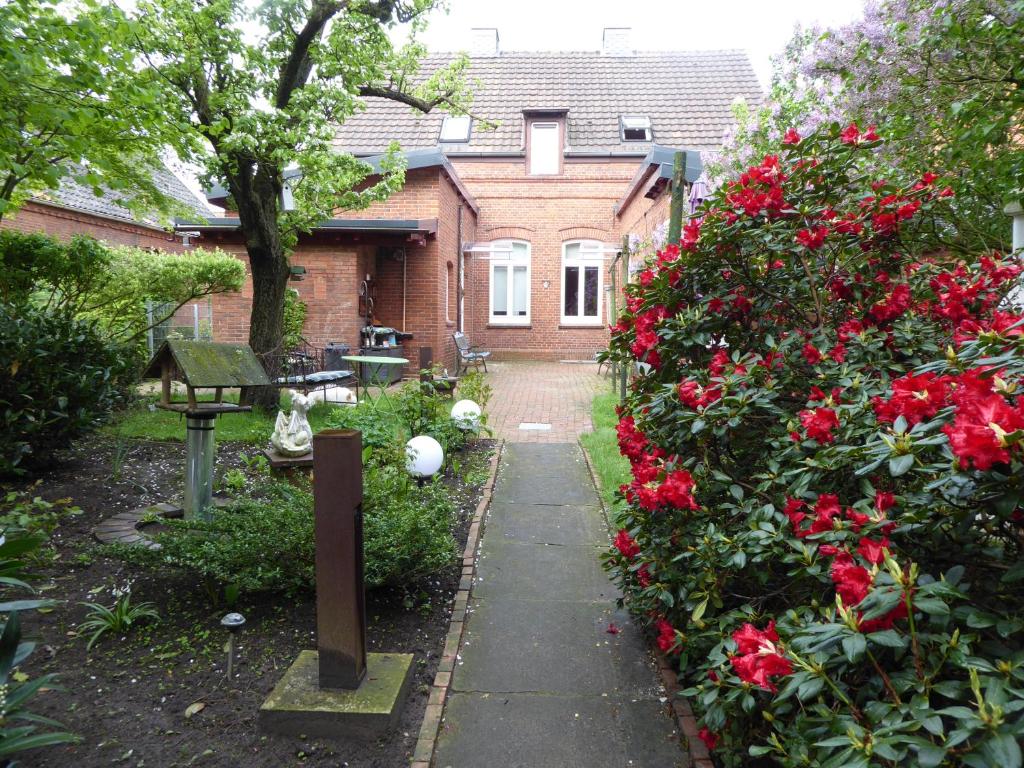 a garden with red roses in front of a house at Großstrasse 18 A in Leer