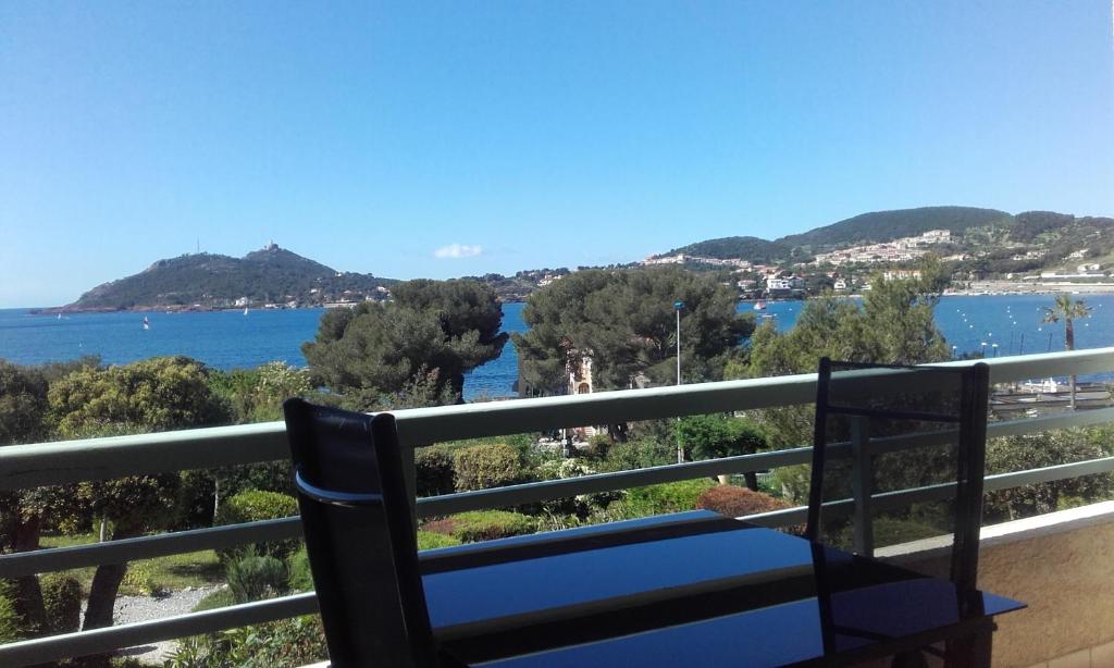 een blauwe bank op een balkon met uitzicht op het water bij appartement vue mer piscines parking LES CORAUX AGAY PLAGE in Agay - Saint Raphael