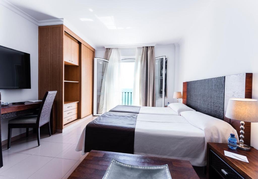 a hotel room with a bed and a desk at Toboso Apar - Turis in Nerja
