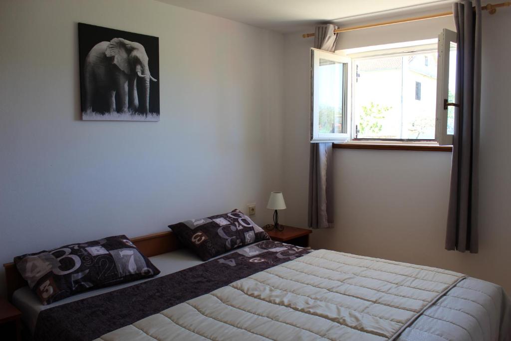 1 dormitorio con 1 cama y una foto de un elefante en Apartman Leni, en Nin