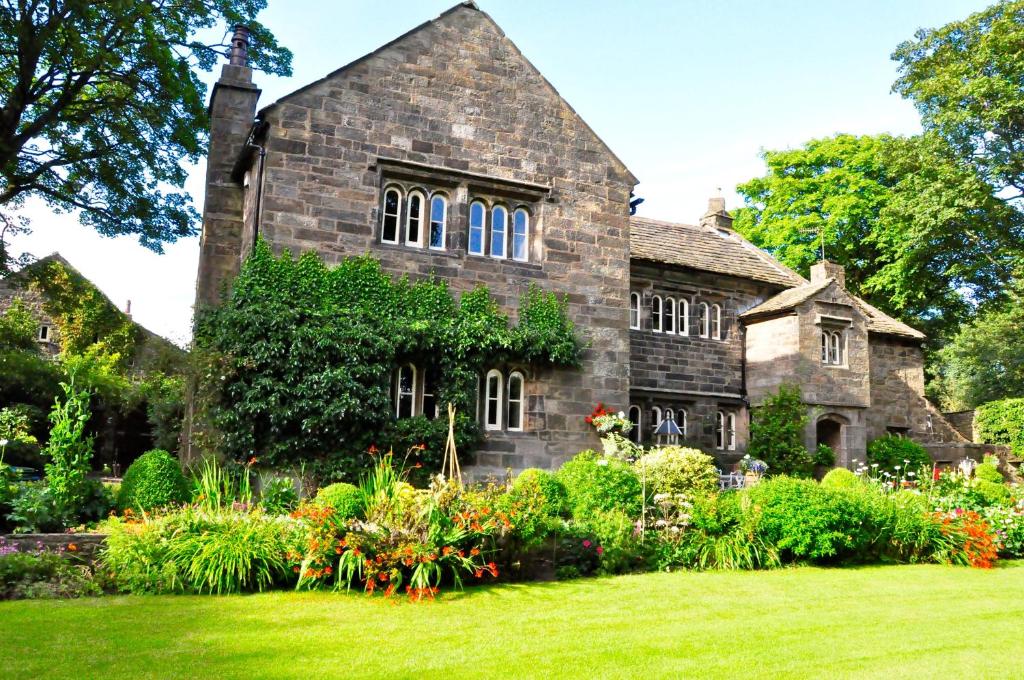 een oud stenen huis met een tuin ervoor bij Hurstwood Hall in Burnley