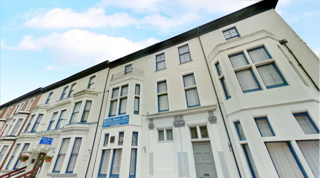 a white building with a black roof at Grafton House in Leicester