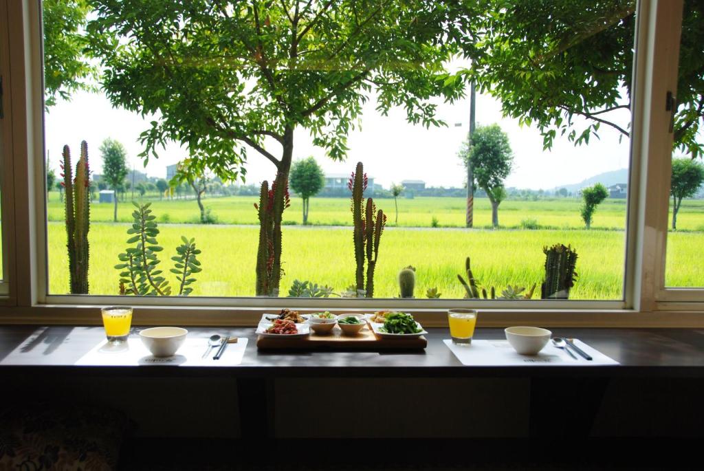 una mesa con un plato de comida y una ventana en Ming Shui Lu Homestay, en Xingjian