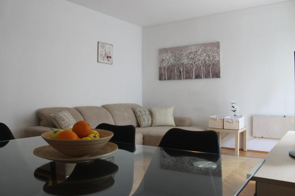 una sala de estar con una mesa con un bol de fruta. en Sweet Home Zadar, en Zadar