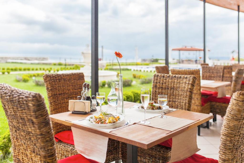 a table with a plate of food and wine glasses at Complex Villas Kaliakra & Gradina in Bŭlgarevo