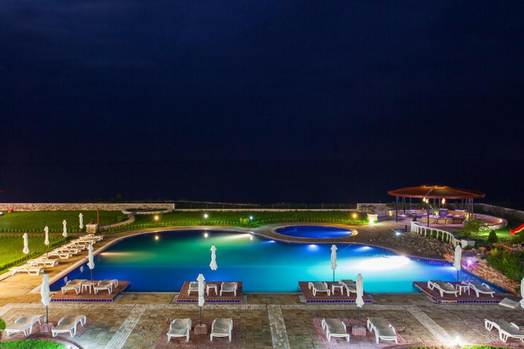 a pool at night with chairs and umbrellas at Complex Villas Kaliakra & Gradina in Bŭlgarevo