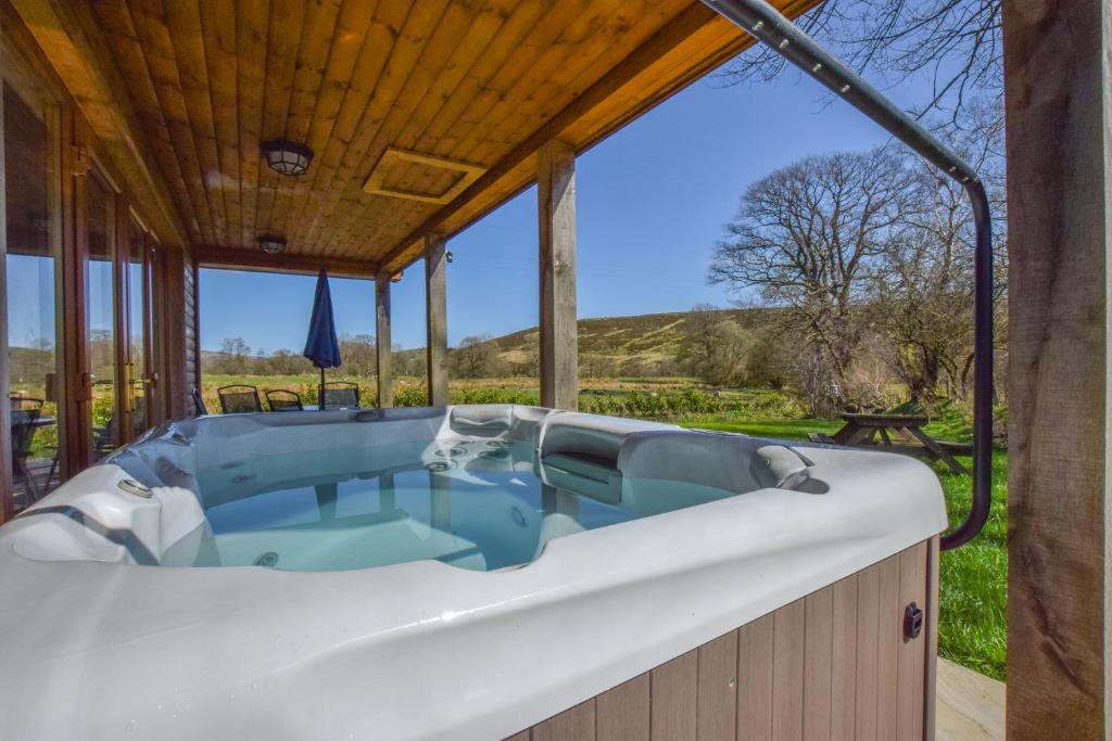 a hot tub in the backyard of a house at LLanddewi Retreat in Llanddewi Ystradenny