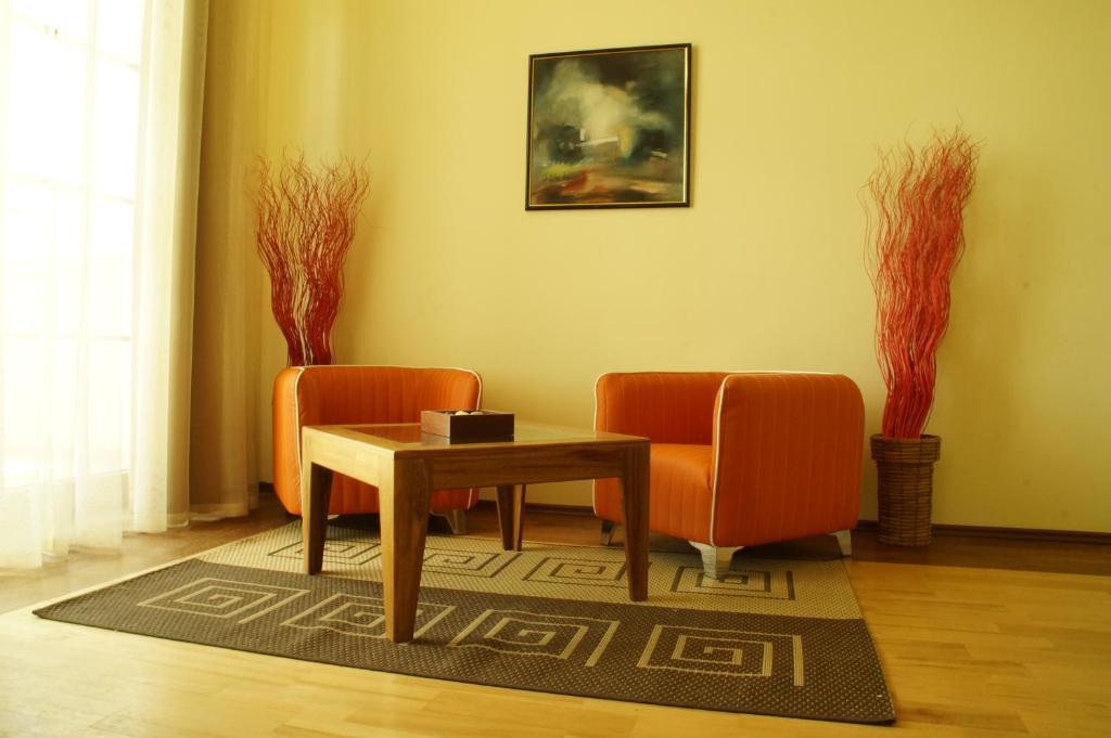 a living room with two orange chairs and a table at Complex Villas Kaliakra & Gradina in Bŭlgarevo