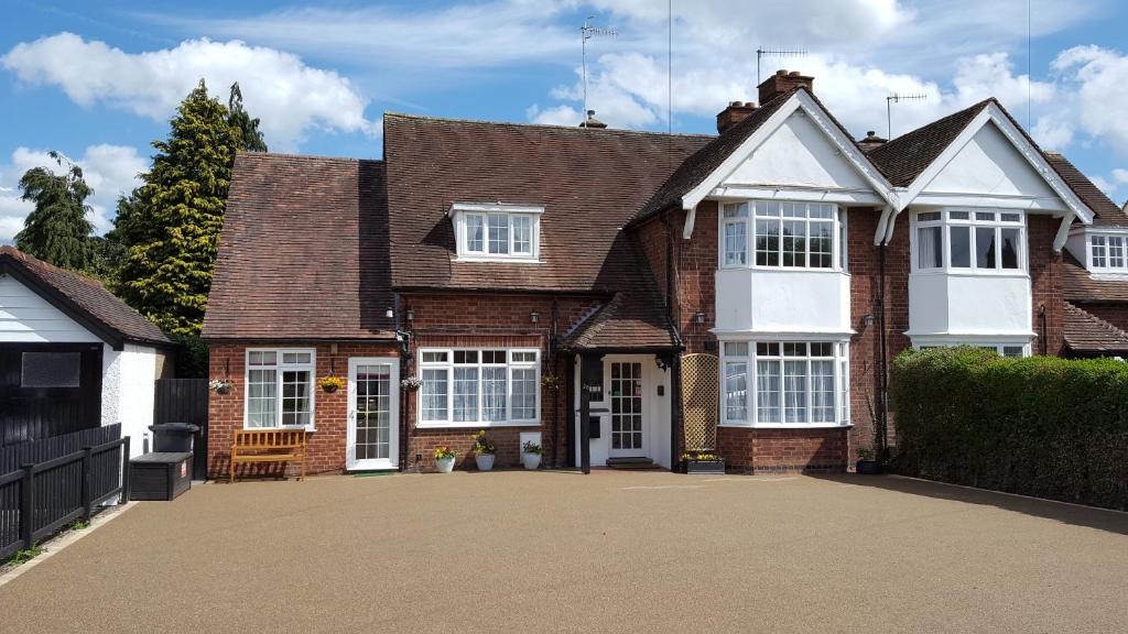 ceglany dom z białymi drzwiami i podjazdem w obiekcie Hampton Lodge En-Suite Rooms with Free Parking w mieście Stratford-upon-Avon