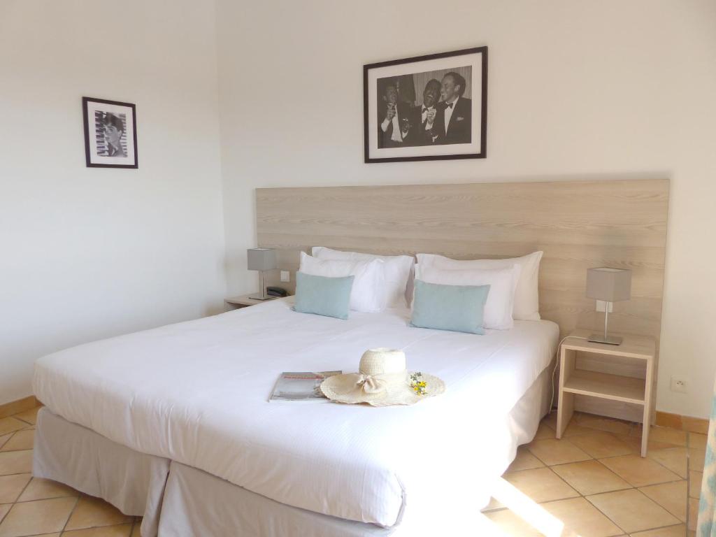 a bedroom with a large white bed with a tray on it at Hôtel les Bouis - Vue mer in Saint-Tropez