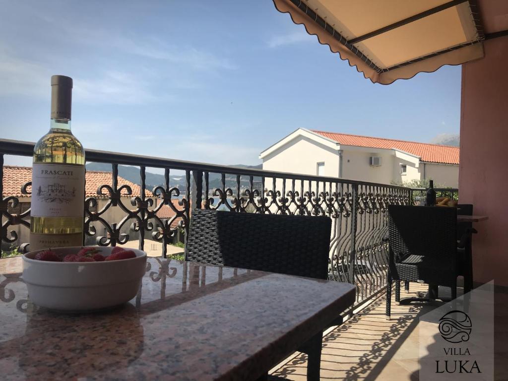 een fles wijn op een tafel op een balkon bij Apartments Villa Luka in Sveti Stefan