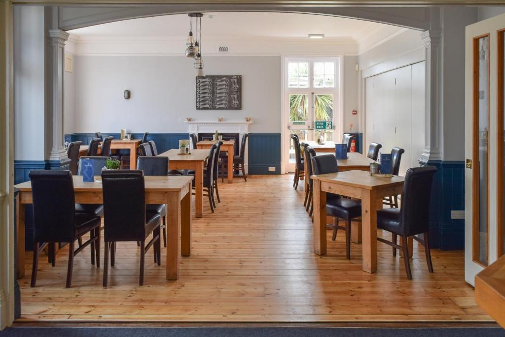 a dining room with wooden tables and chairs at The Randolph Hotel in Southwold