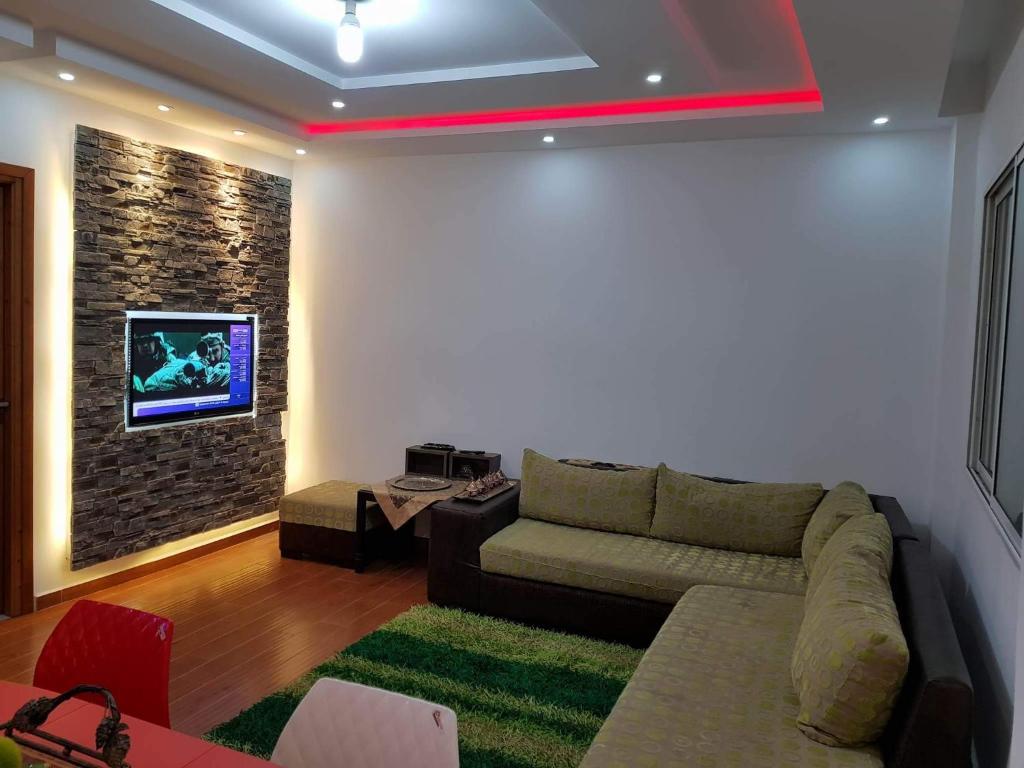un soggiorno con divano e TV a parete di APPARTEMENT "DINA" Kélibia a Kelibia
