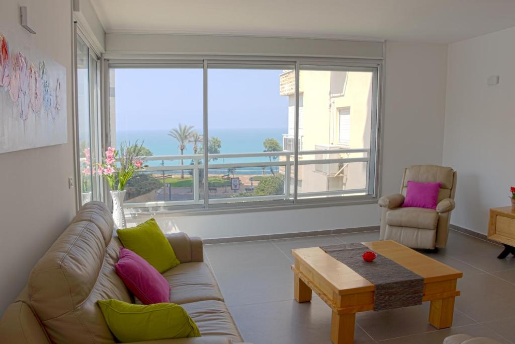 a living room with a couch and a coffee table at Nitza Boutique Apartment Kosher in Netanya