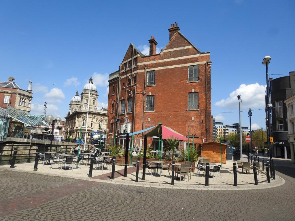 a building with tables and chairs in front of a building at Princes Dock Chambers 7 in Hull