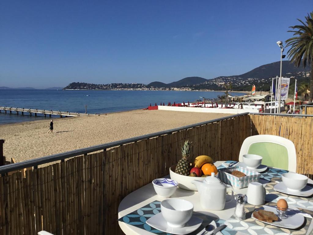 une table sur un balcon avec vue sur la plage dans l'établissement Résidence des Sables d'Or, à La Croix-Valmer