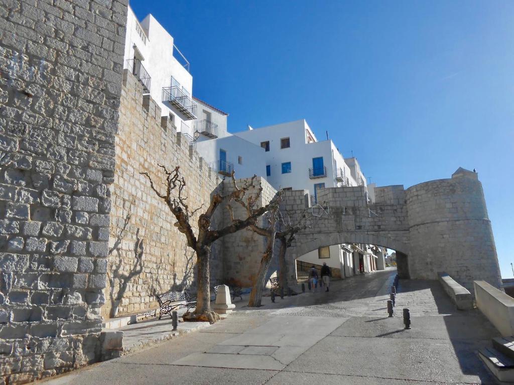 an old stone bridge over a street next to a building at Casa casco antiguo, junto al Bufador in Peniscola