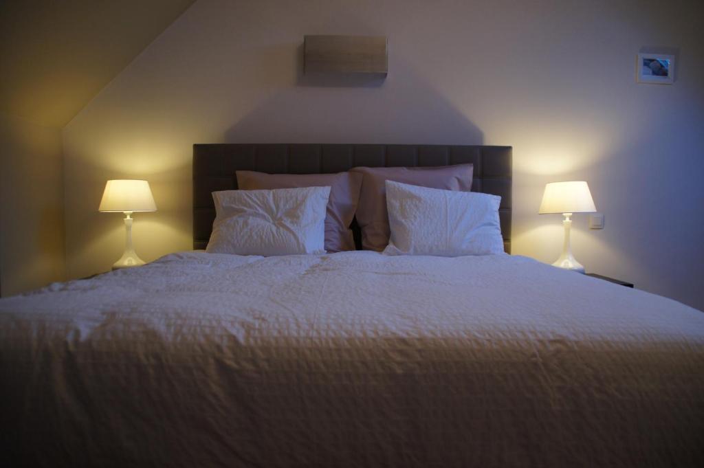 a bedroom with a large white bed with two lamps at All Inn Holiday Home in Ghent