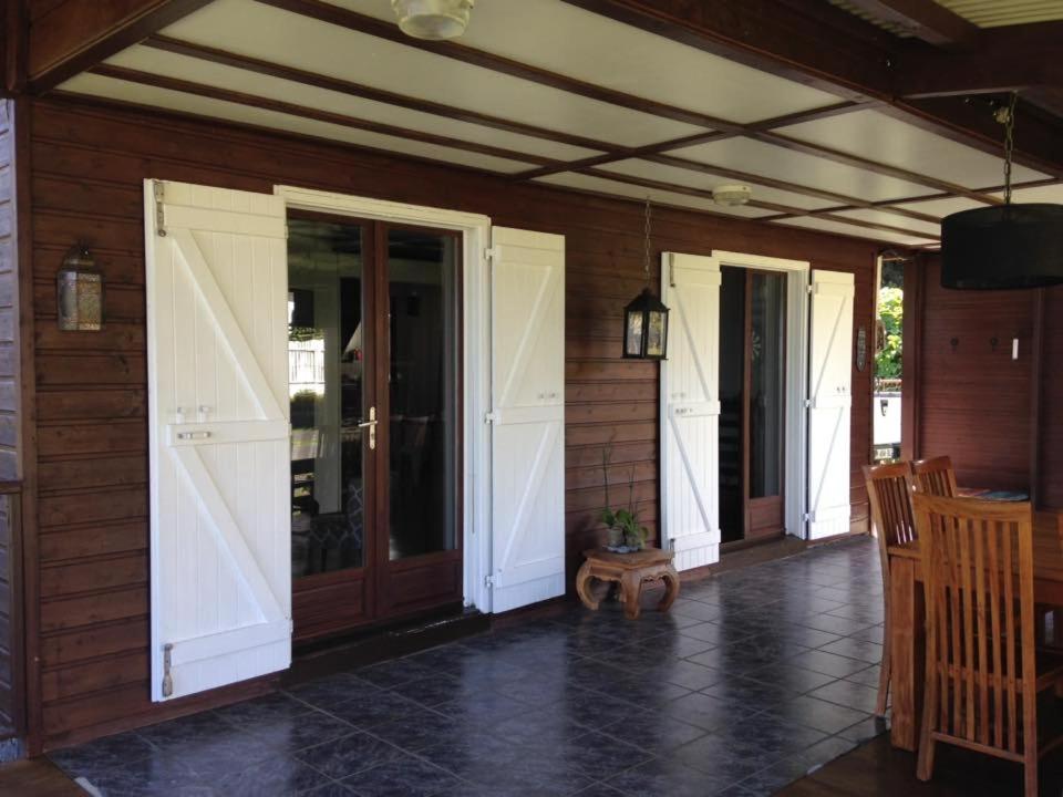 eine Veranda eines Hauses mit zwei Türen und einer Veranda in der Unterkunft lesept in La Plaine des Cafres