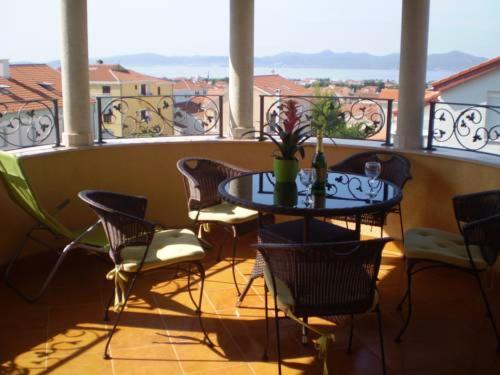 a balcony with a table and chairs and a window at Villa Jelena in Zadar