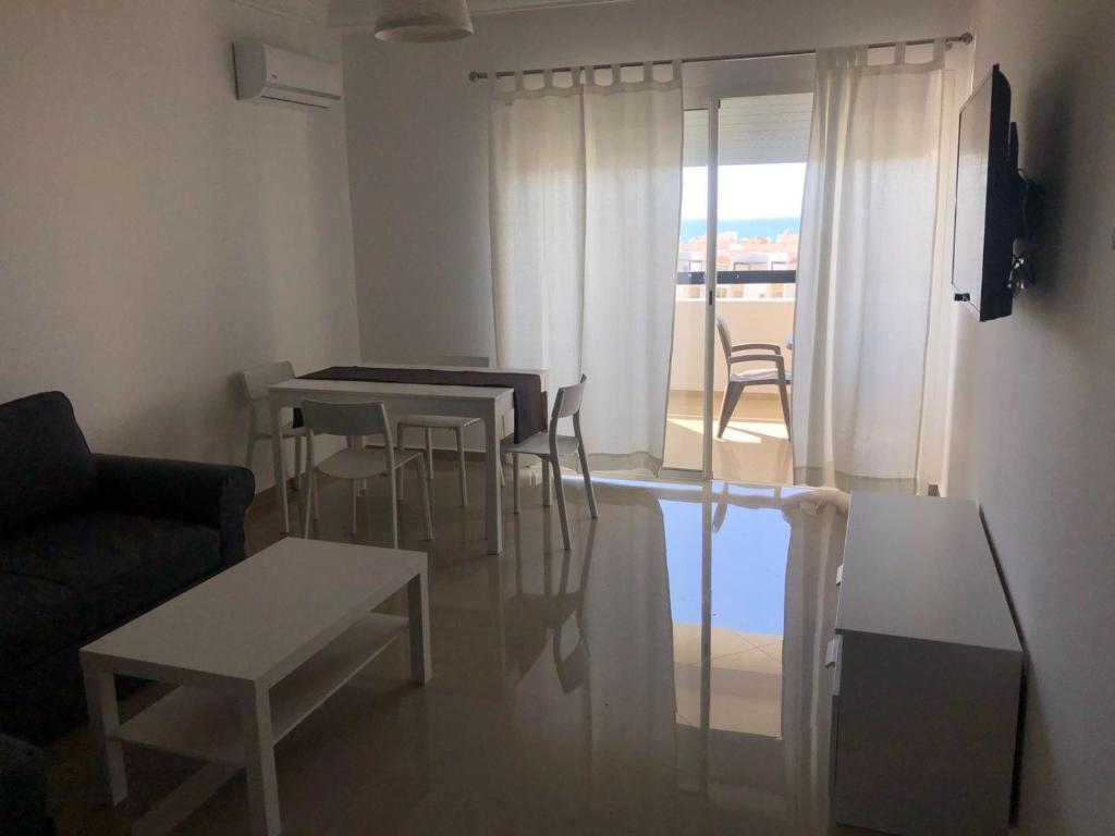 a living room with tables and chairs and a couch at Marina Golf Appart Chez Hicham in Asilah