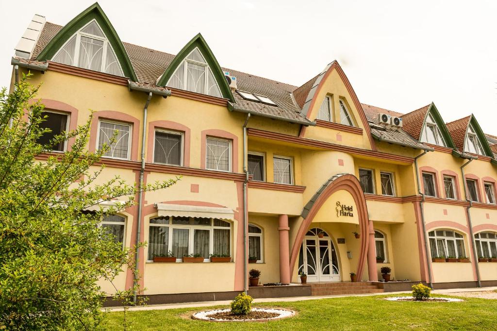 ein großes gelbes Gebäude mit einem Gammeldach in der Unterkunft Hotel Harka in Harkány