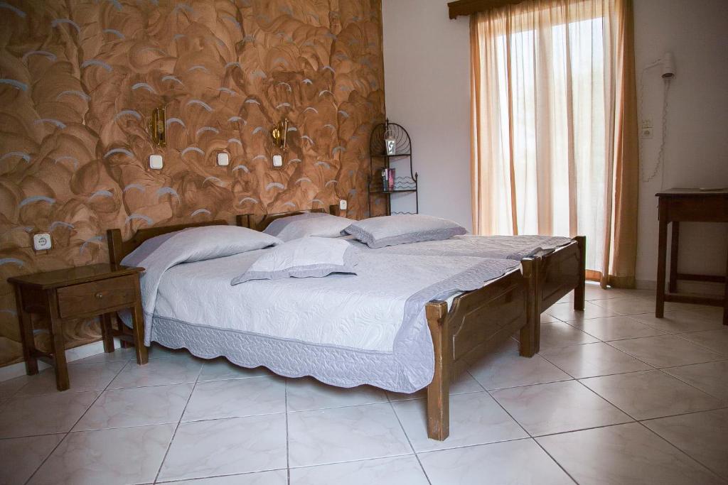 um quarto com uma cama e uma cabeceira em madeira em Matina Studios em Kefalos