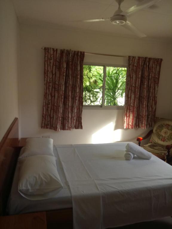 a bedroom with two beds and a window at Awesome Charlie D Villas in Anse Kerlan