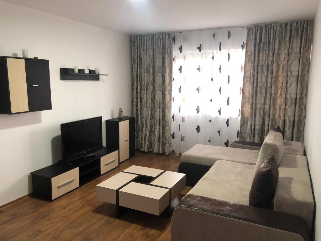 a living room with a couch and a tv at Apartament Bella in Jurilovca