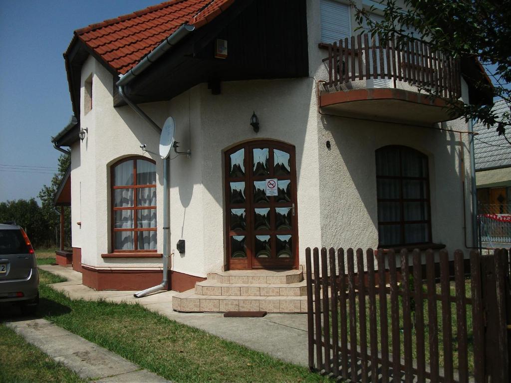 ein kleines Haus mit einem Balkon und einer Tür in der Unterkunft Zsuzsanna vendégház in Mezőkövesd