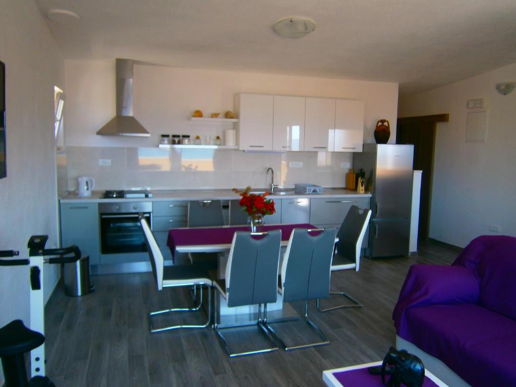 a kitchen and living room with a table and chairs at Apartment Willy in Komiža