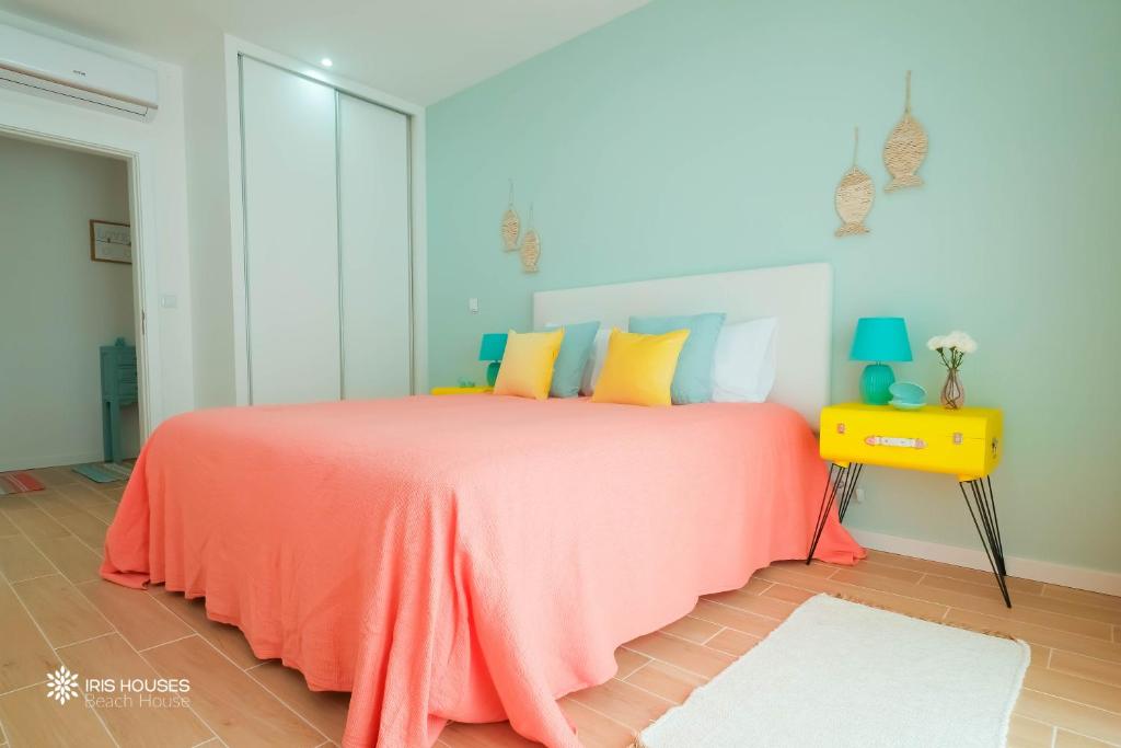 1 dormitorio con 1 cama con manta naranja en Iris Apartment, en Nazaré