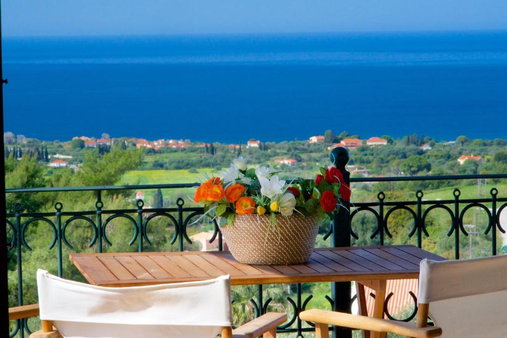 a table with a basket of flowers on a balcony at Sea View Antigone's Villa with playground in Metaxáta