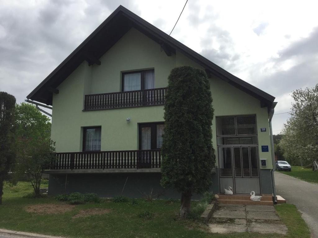 une maison avec un arbre en face dans l'établissement Ivana, à Saborsko
