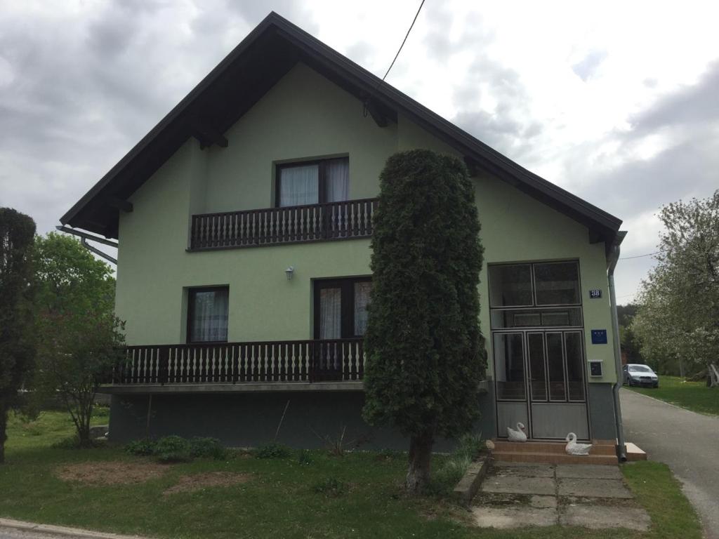 a house with a tree in front of it at Ivana in Saborsko