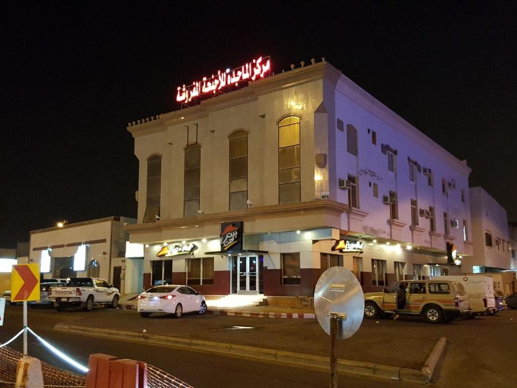 a building with a sign on top of it at night at Al Majdah Hotel in Medina