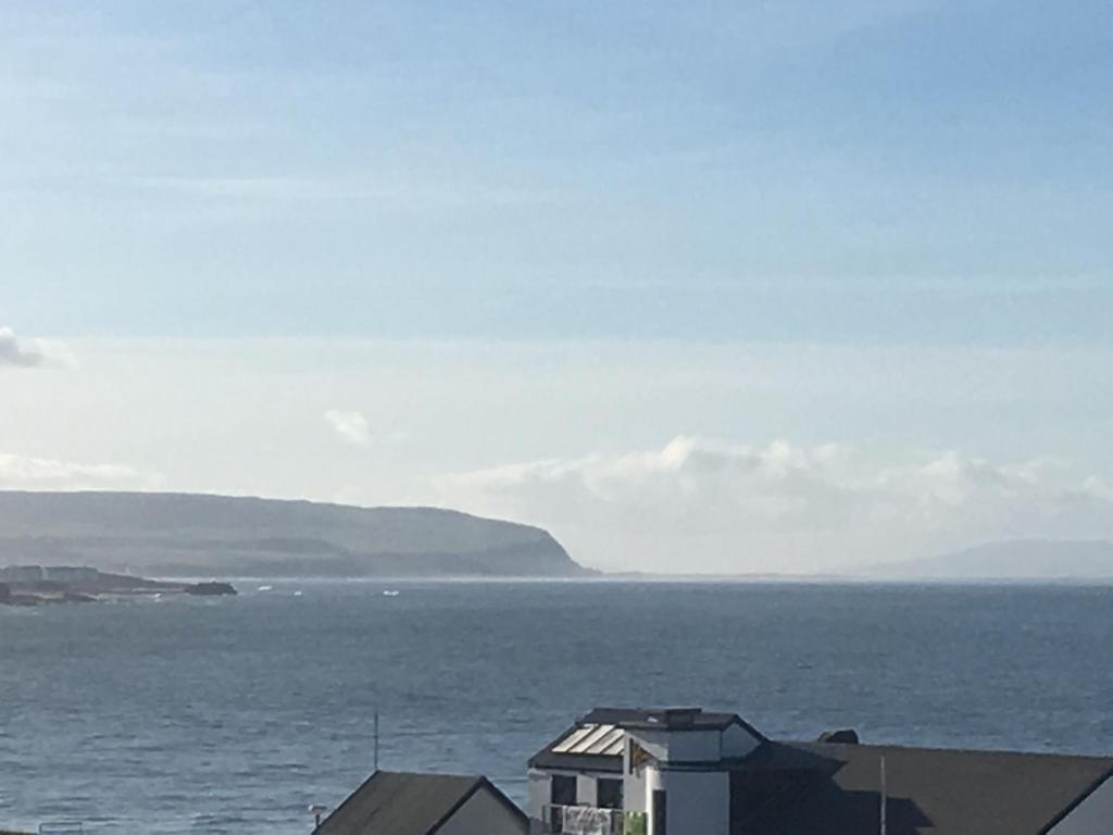 a view of a body of water with a house at Royale Court Apartments Portrush in Portrush