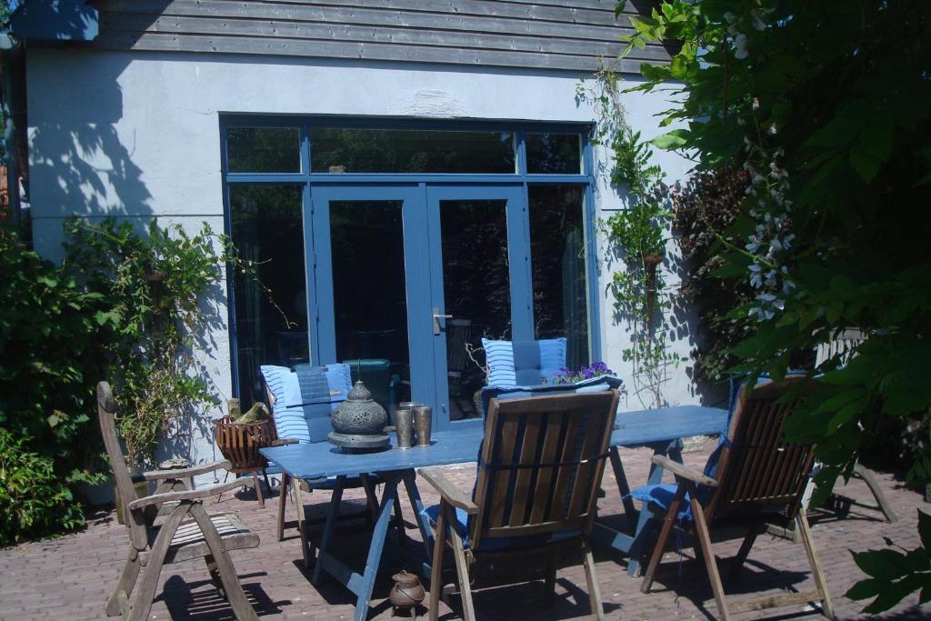 a blue table and chairs in front of a house at B&B De Lotus in Hoevelaken