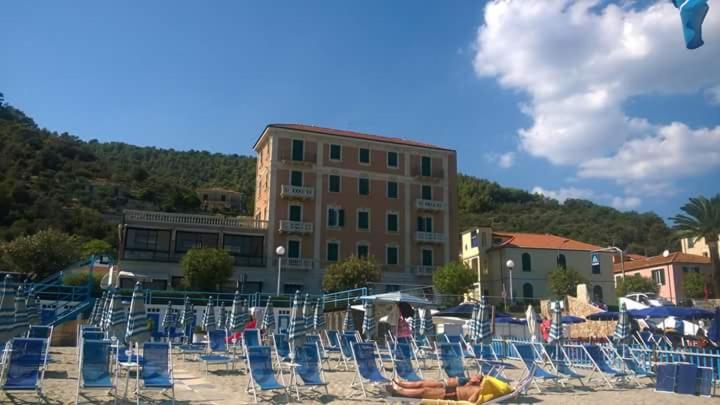 - un bouquet de chaises assises sur une plage dans l'établissement Hotel Monique, à Noli