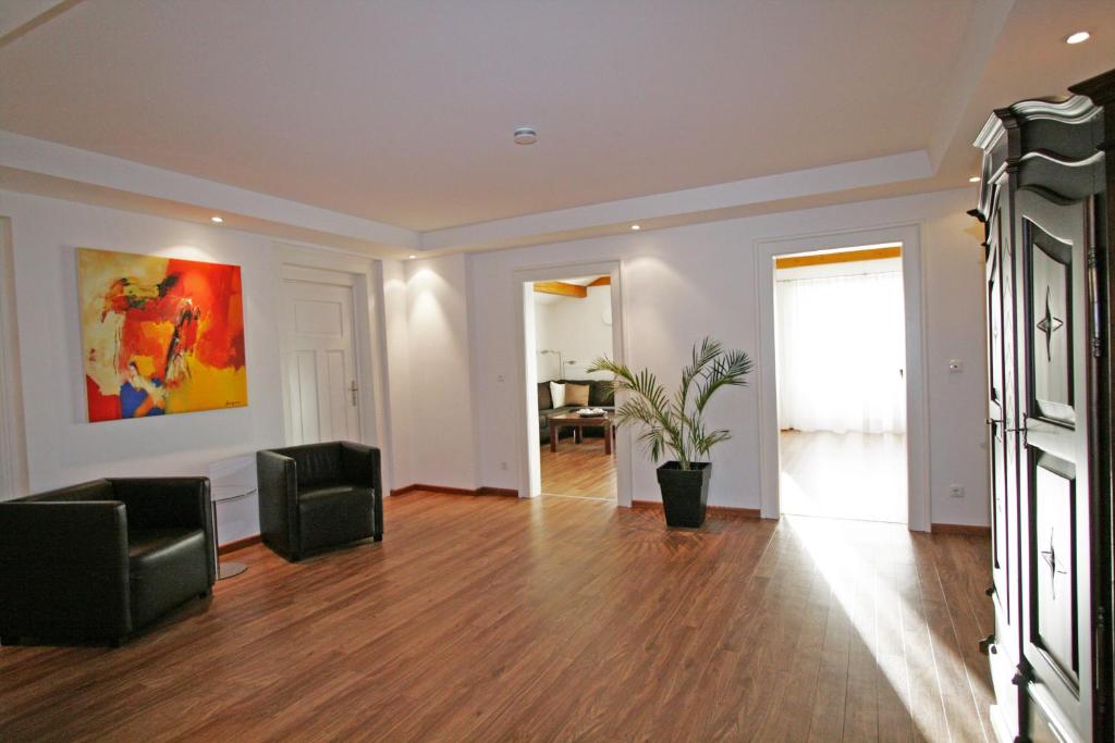 uma sala de estar com duas cadeiras e um quadro na parede em Ferienwohnung Am Kurpark -Wohnung 3,150qm- mit Lift em Garmisch-Partenkirchen